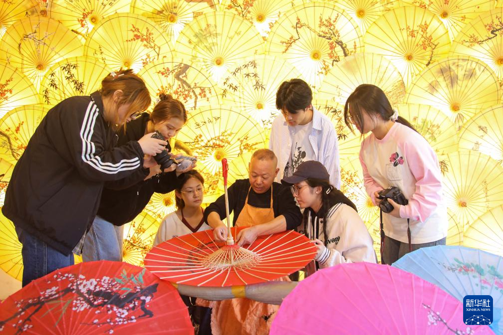 在泾县昌桥乡孤峰村的国民油布伞厂，省级非物质文化遗产传承人郑国民为前来研学的学生介绍油布伞制作技艺。